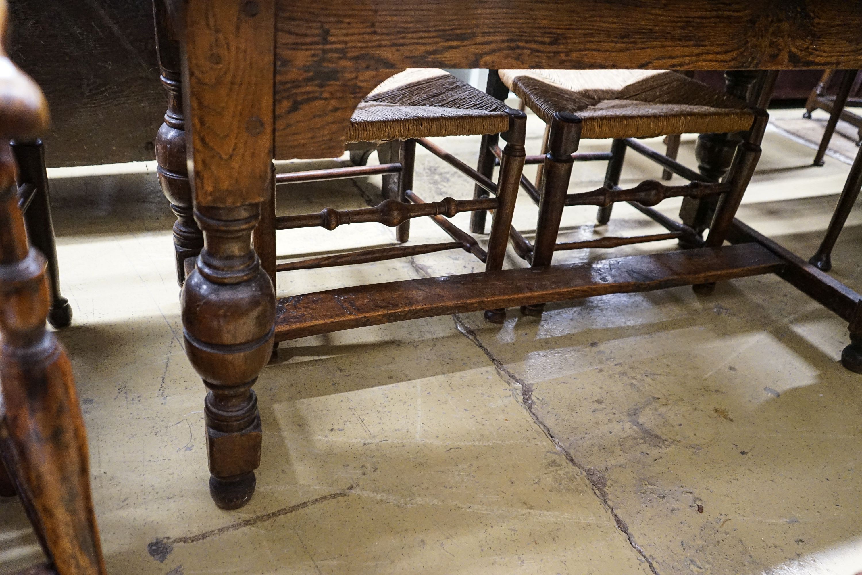 A 17th century style oak refectory table, with cup and cover legs and H stretcher, length 177, depth 74cm, height 77cm